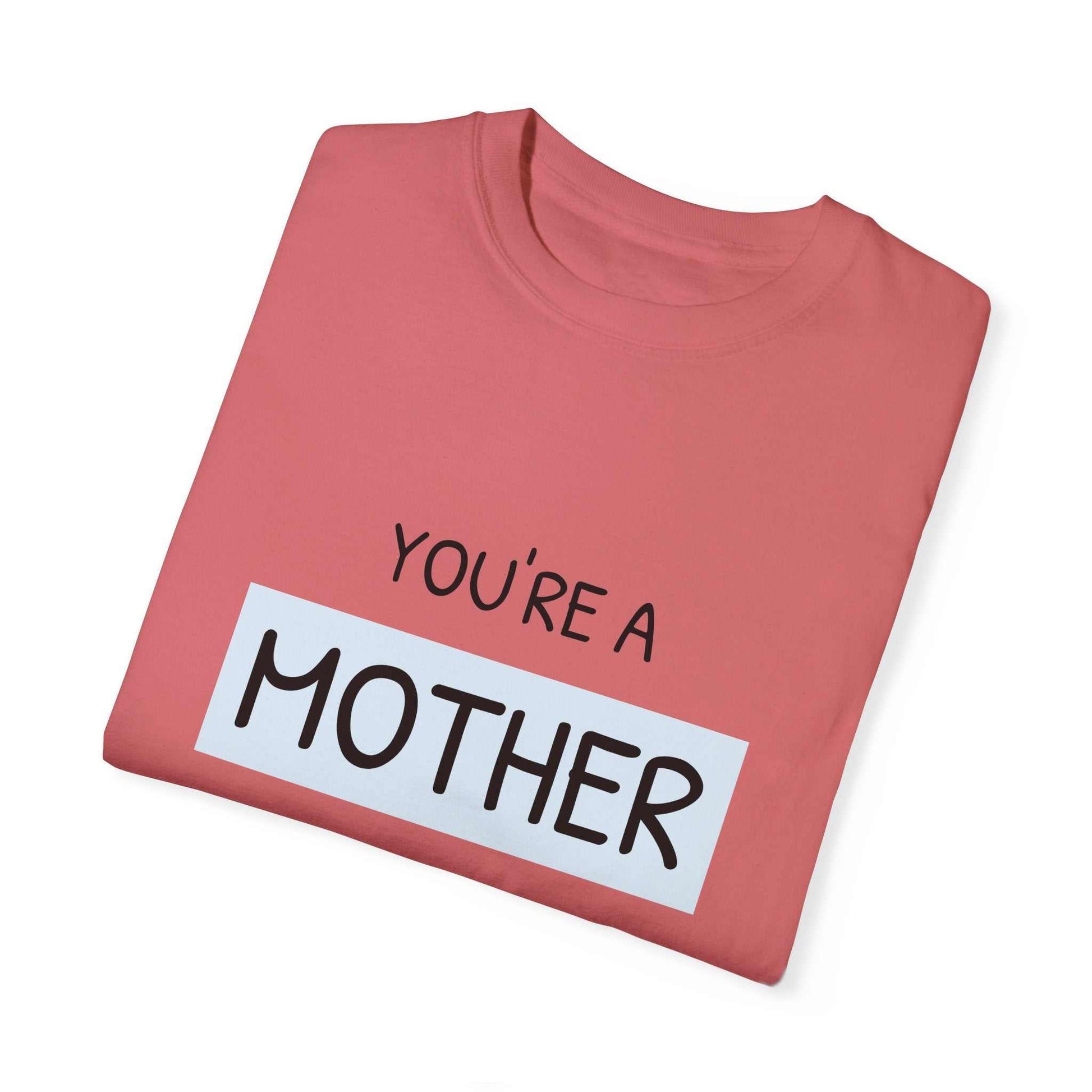 Folded pink T-shirt with "You're a Mother" printed on it, celebrating motherhood and individuality.