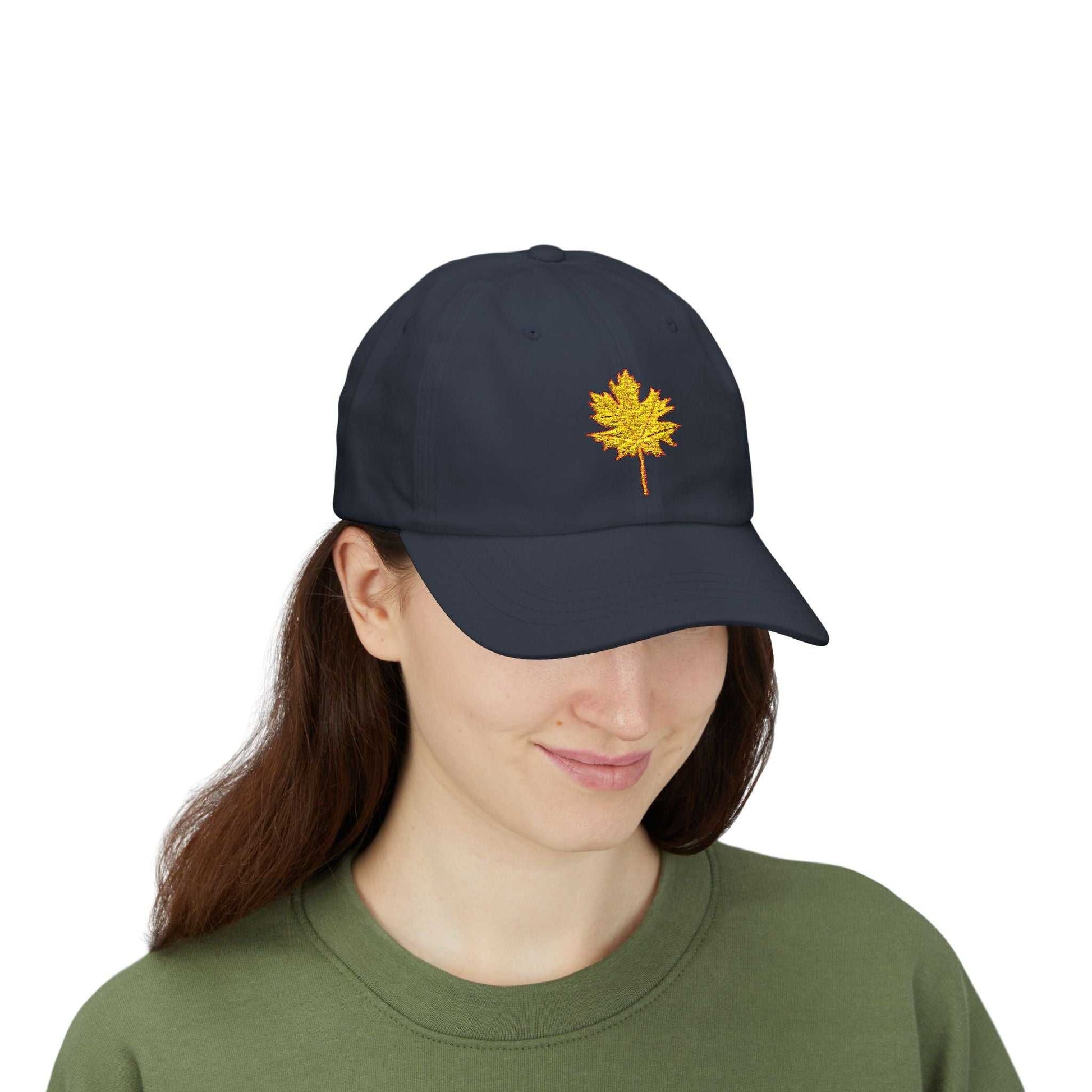 Woman wearing a black dad cap with a yellow maple leaf embroidery.
