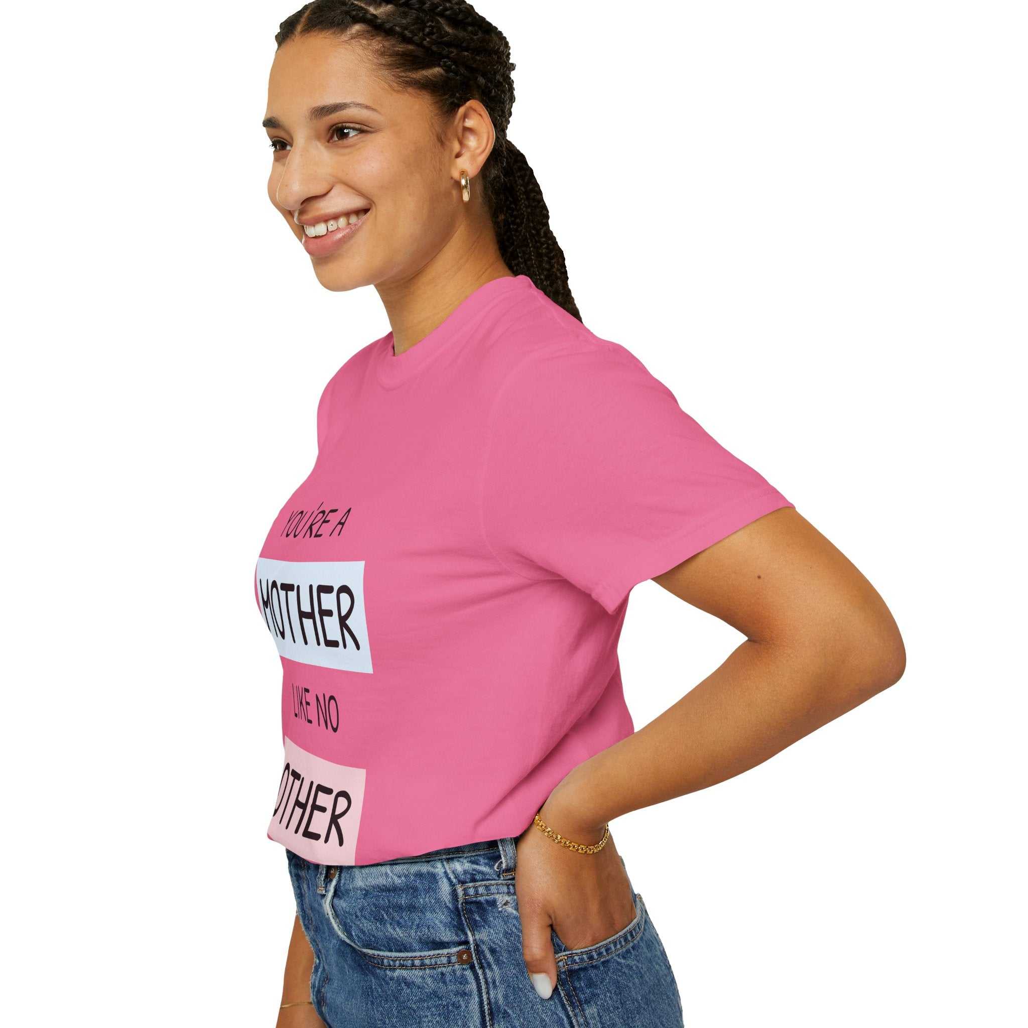 Pink T-shirt with "You're a Mother Like No Other" text, showcased by a smiling person, emphasizing warmth and individuality for mothers.