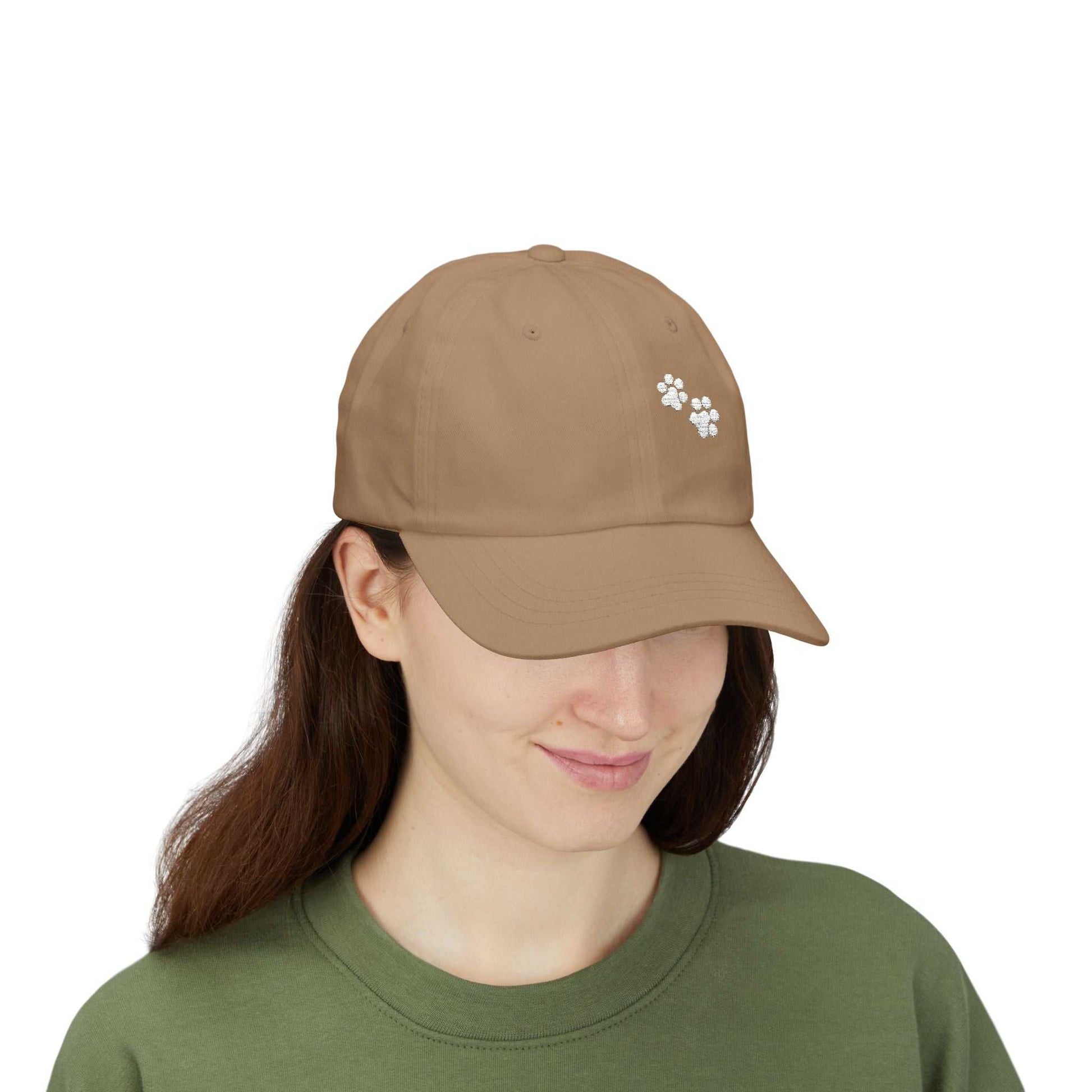 Classic Dad Cap with paw print design, worn by a smiling person wearing a green top, showcasing casual style.